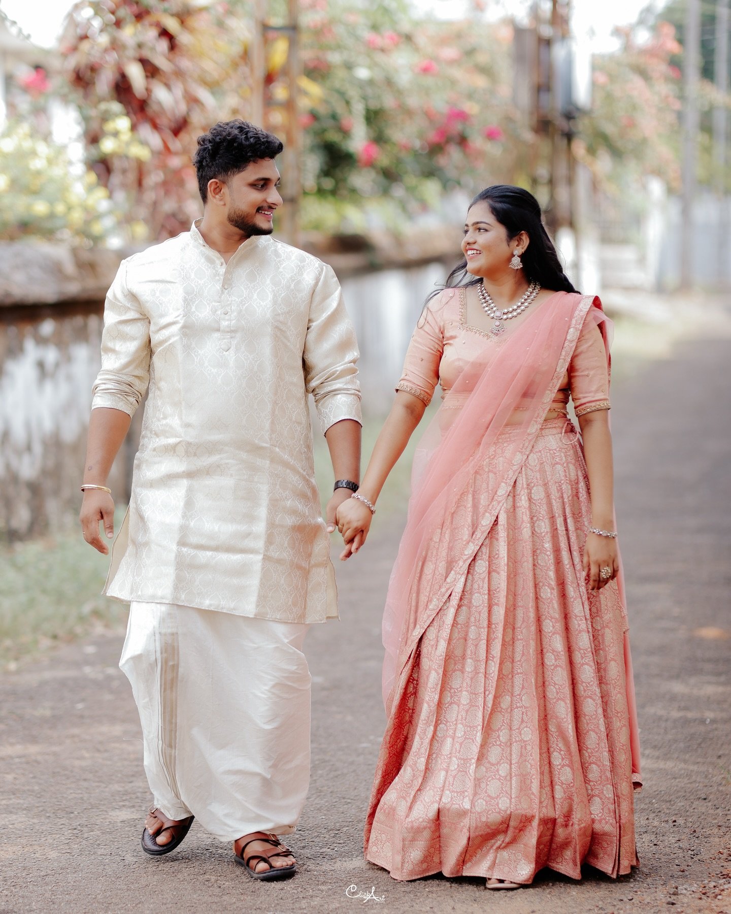A couple walking hand in hand in traditional celebration attire